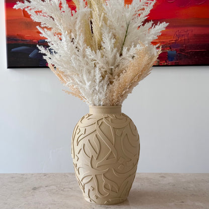 Round Arabic calligraphy vase in Bone finish styled with white pampas grass on a stone console