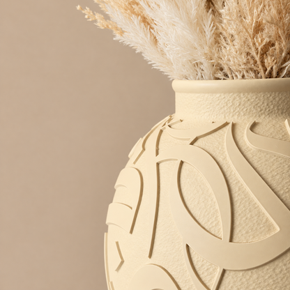Close-up of raised Arabic calligraphy on a Bone matte vase with dried pampas grass